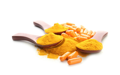 Spoons with turmeric powder capsules on white background