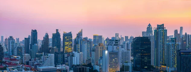 Fotobehang Panorama view of downtown Bangkok cityscape with high rise skyscraper tall building during pink sunset sky © Akarawut