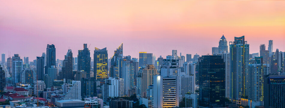 Fototapeta Panorama view of downtown Bangkok cityscape with high rise skyscraper tall building during pink sunset sky