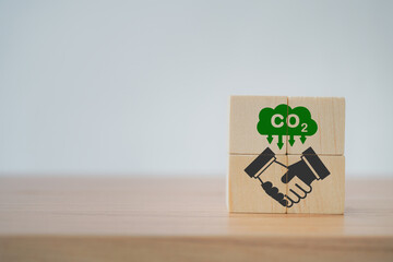 handshake icon on wooden cubes with CO2 emission reduction icon for  CO2 emission ,green industries...