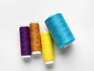 Different thread spools on white background