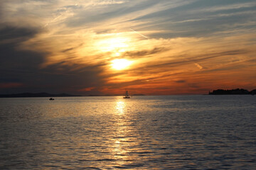 sunset at sea and boat. variety of colors and hues of the rising sun. Sea landscape.