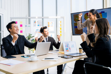 Fototapeta premium A group of young businessmen in suits, Asians, are determined and excited about their work. and encourage the team members by raising their hands happily