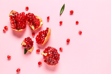 Tasty ripe pomegranate pieces on pink background