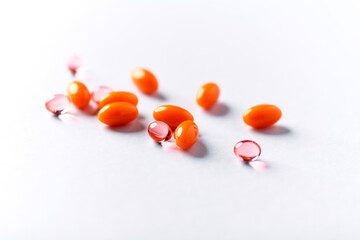 Vitamin E and Coenzyme Q10 capsules. Antioxidants. Concept for a healthy dietary supplementation. Bright paper background. Soft focus. Close up. Copy space.	