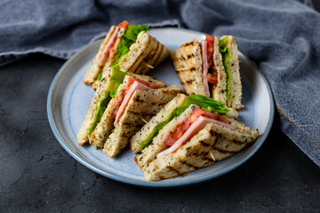 sandwich with ham cheese tomatoes lettuce onions on plate. Classic club sandwich with whole grain bread