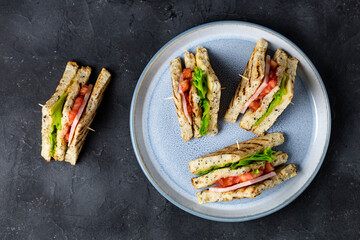 sandwich with ham cheese tomatoes lettuce onions on plate. Classic club sandwich with whole grain bread