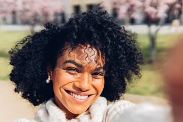 Attractive black woman taking a selfie photo on the street Beautiful smiling Hispanic girl, walking...