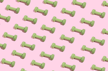 Modern minimal pattern with green dumbbells on bright pink background. Trendy female fitness...