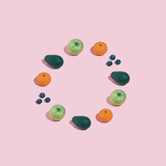 Round shape made with avocado, orange, blueberries and apple. Modern minimal healthy eating concept with copy space.