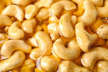 Sweet cashew nuts in honey as background