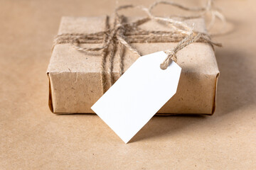 empty white gift tag mock up on craft paper box on natural beige background. - Powered by Adobe