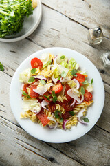 Pasta salad with mozzarella, red onion and tomato