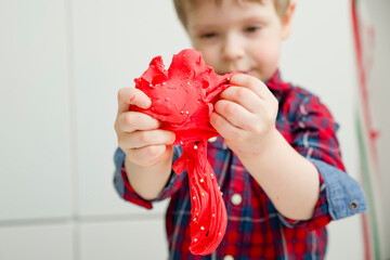 kid plays with Slime. Activities at home. toy as sensory device, to stimulate imagination, to calm...