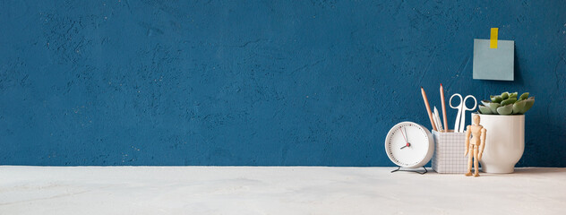 Home office desk with blue wall and white table mock up. Banner.