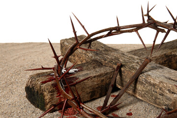 Crown of thorns with wooden cross, nails and blood drops on sand against white background