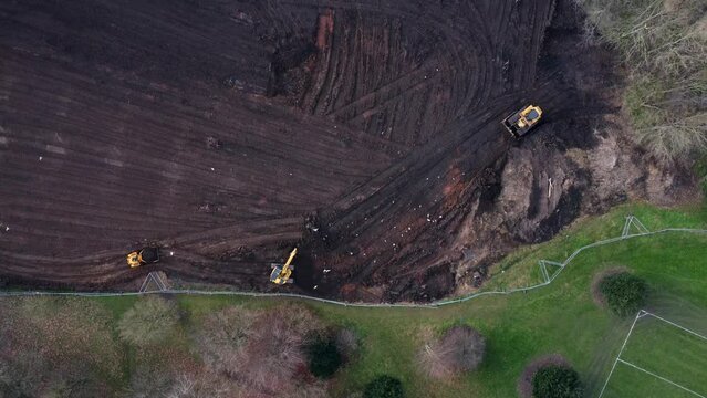 Aerial view of diggers and construction plant in dirt and mud