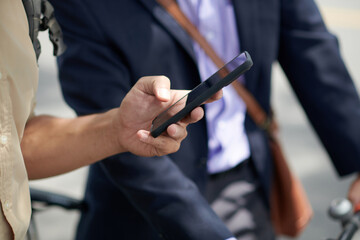 Closeup image of businessman reading text message from colleague on smartphone