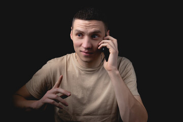 Studio portrait of a man with a smartphone on a black background.