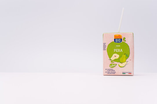Healthy nutrition concept - Organic pear juice drink in a mini Tetra Pak container with straw isolated on a white background