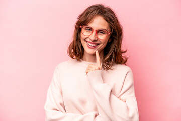 Young caucasian woman isolated on pink background smiling happy and confident, touching chin with hand.