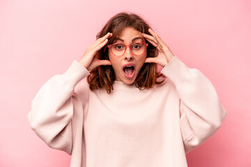 Young caucasian woman isolated on pink background receiving a pleasant surprise, excited and raising hands.