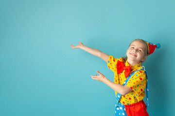 Funny kid clown against blue background. Birthday and 1 April Fool's day concept. Copy space