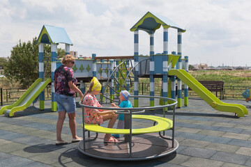Family on a new playground on Kirov street in the village of Uyutnoye, Evpatoria, Crimea