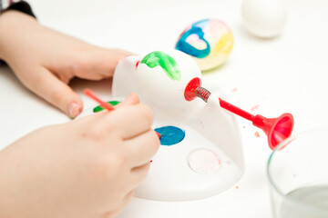 Happy Easter. Boy painting Easter eggs. Religious holiday. Early education and artistic preschool activities. Child having fun and celebrating feast.