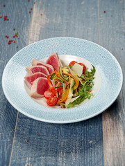 rare seared Ahi tuna slices with fresh vegetable salad
