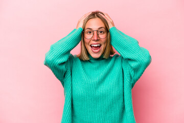 Young caucasian woman isolated on pink background screaming, very excited, passionate, satisfied with something.