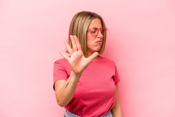 Young caucasian woman isolated on pink background rejecting someone showing a gesture of disgust.