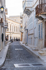 Fototapeta na wymiar Neoclassical building and empty paved street at Syros island, Hermoupolis town, Cyclades, Greece