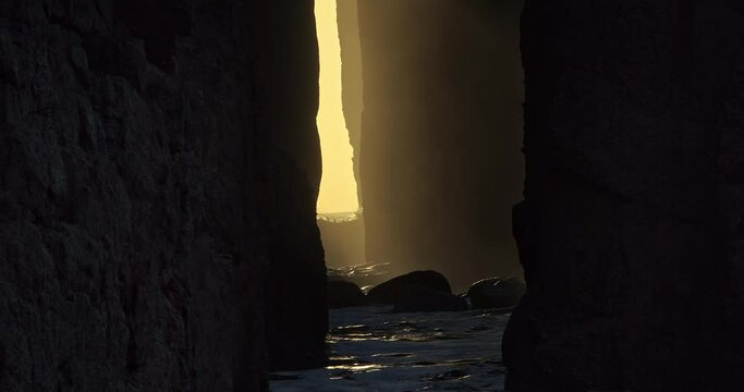 Sunlight Illuminated Through Zawn Pyg Natural Arch With Crashing Waves At Nanjizal Beach In Cornwall, United Kingdom. Close Up