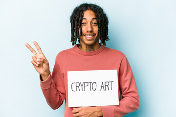 Young African american man holding crypto art placard isolated on blue background joyful and carefree showing a peace symbol with fingers.