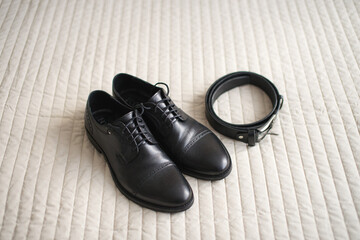 Black men's shoes with laces and a black belt