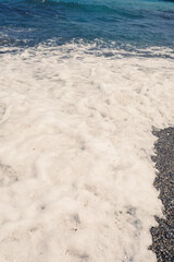 Sea water from a wave with foam on the seashore