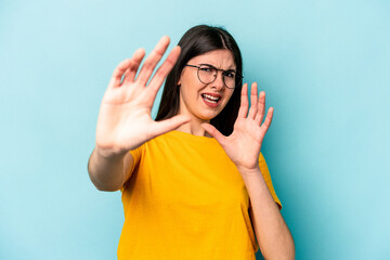 Young caucasian woman isolated on blue background being shocked due to an imminent danger