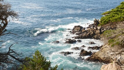 Rocky craggy ocean coast and cypress grove, blue water waves and coniferous pine tree forest, scenic 17-mile drive, Monterey nature near Point Lobos, Big Sur and Pebble beach, California USA. Seascape