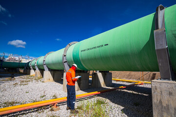 Male worker inspection visual big pipeline green power plant generates electricity water