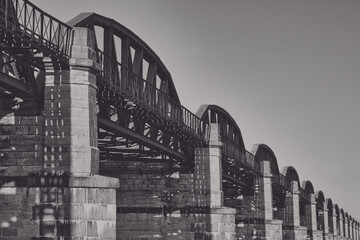 old rusty steel railway bridge with arches