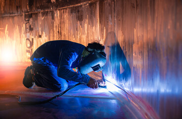 Welding  arc argon worker male repaired metal is welding sparks industrial construction tank...