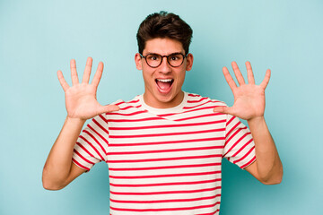 Young caucasian man isolated on blue background receiving a pleasant surprise, excited and raising hands.