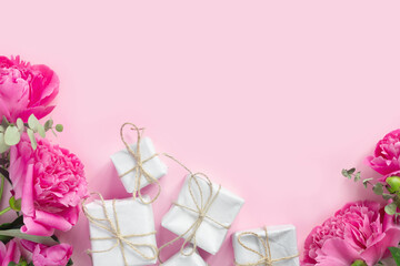Bouquet of beautiful pink peonies with gift boxes in paper wrapping. Banner for congratulations or invitation.