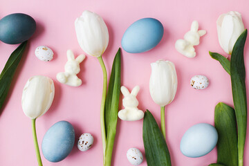 Fototapeta na wymiar Easter composition. Stylish eggs, tulips, bunnies flat lay on pink background. Modern natural dyed blue easter eggs and white tulips layout. Greeting card template, easter background