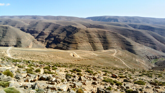 Scenic view of a field between the gray mountains under the clear sky in Morocco