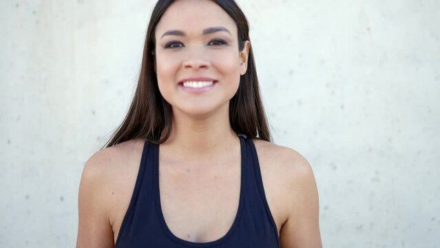 Smiling ethnic woman in sportswear looking at camera