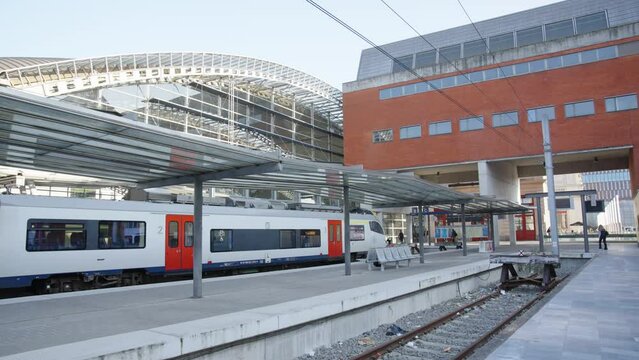 Facade of the Leuven railway station at day. Train waiting at terminus, ready to depart and transport passengers - Belgium
