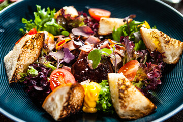 Warm chicken liver salad with port wine-honey sauce. Carrot cream, bacon, cherry tomatoes, brioche. Delicious healthy traditional food closeup served for lunch in modern gourmet cuisine restaurant