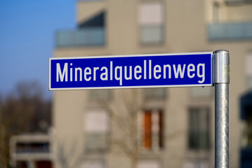 Street sign with word Mineralquellenweg (German, translation ist way of mineral spring) on a sunny spring day. Canton Zürich. Photo taken March 7th, 2022, Zurich, Switzerland.